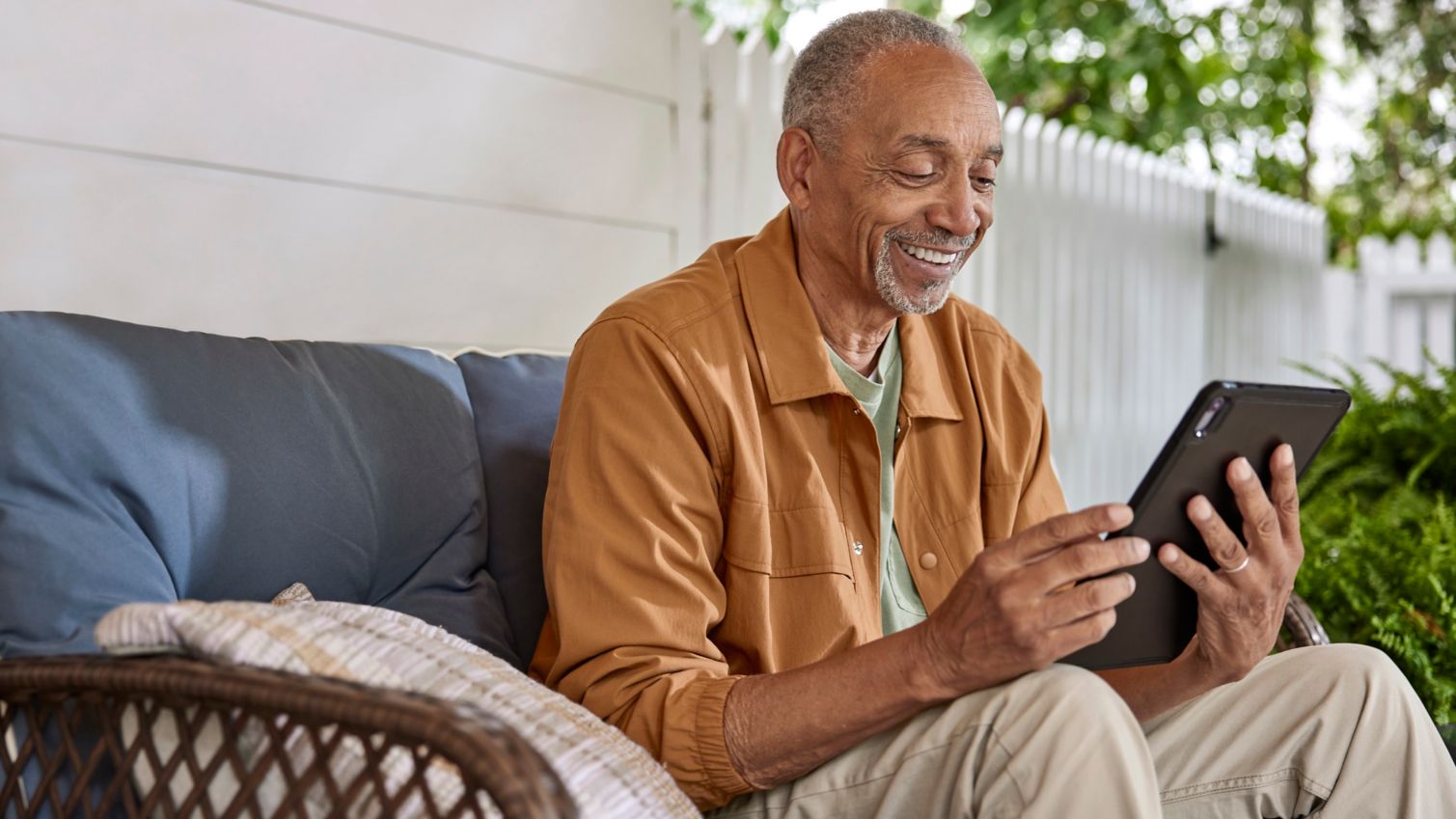 Senior looking at tablet on a porch