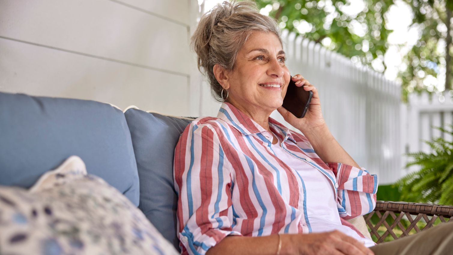 Senior sitting outdoors talking on the phone.