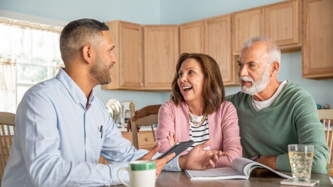 Senior couple sitting at kitchen table with Humana agent.