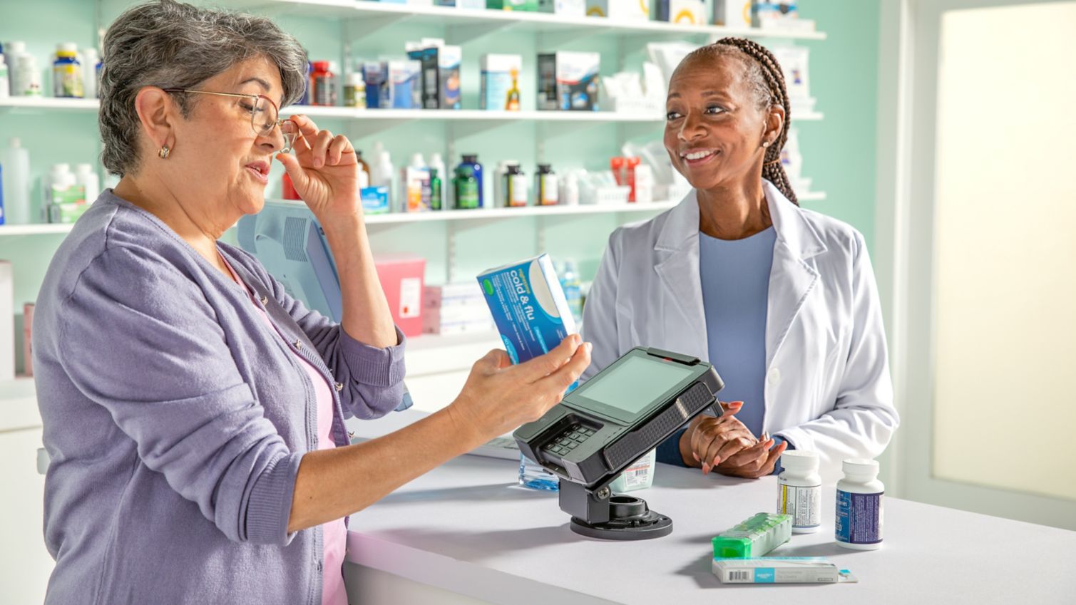 Woman talking to a pharmacist at a counter.