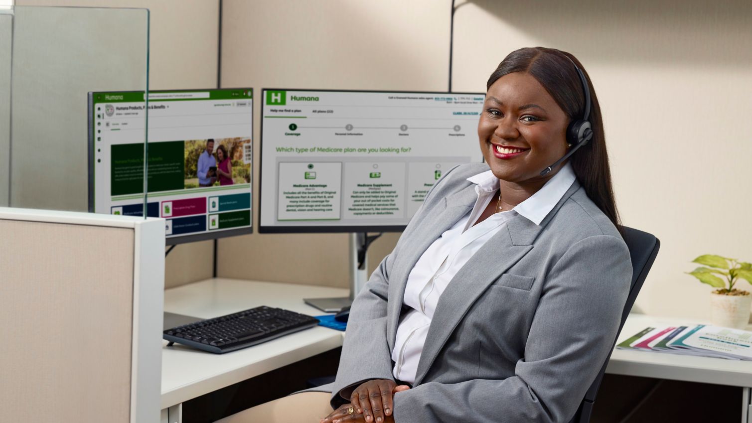 Human call center agent smiling at her desk. 