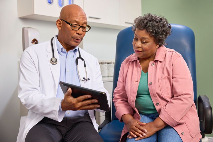 Doctor shows a woman a chart in a doctor’s office.