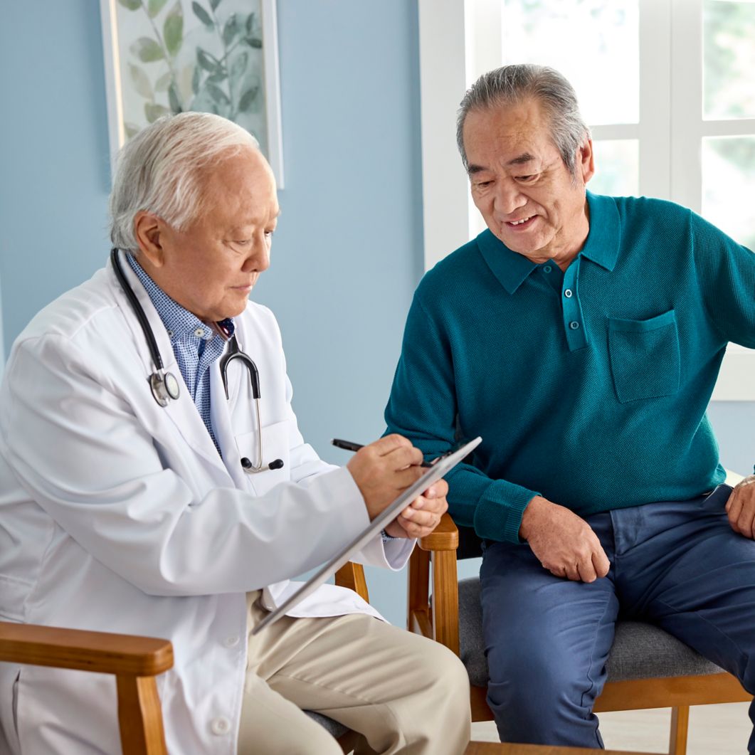 Doctor speaking to man in doctor’s office.