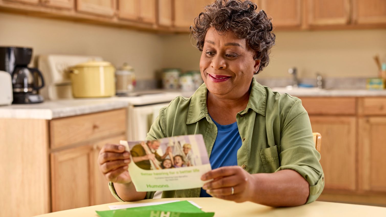  Woman reading Humana brochure at a table.