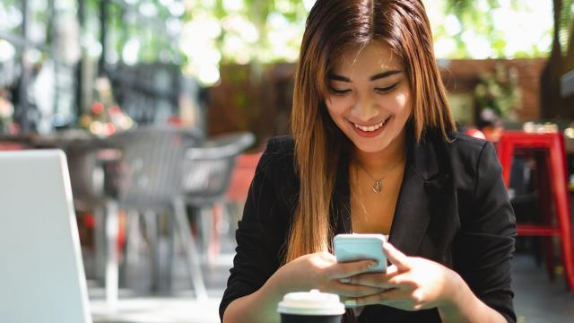 Woman using smartphone at coffee shop.