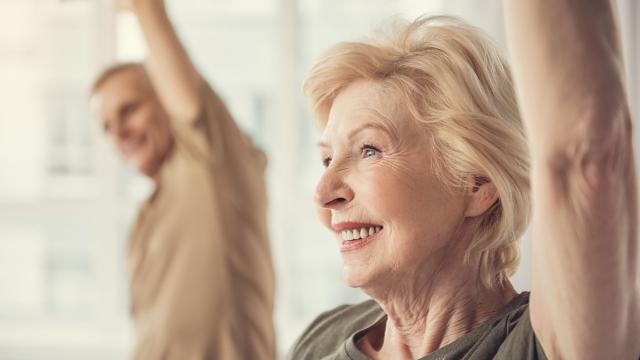 Older woman smiling while working out at gym.