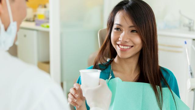 Young woman smiling at dentist.
