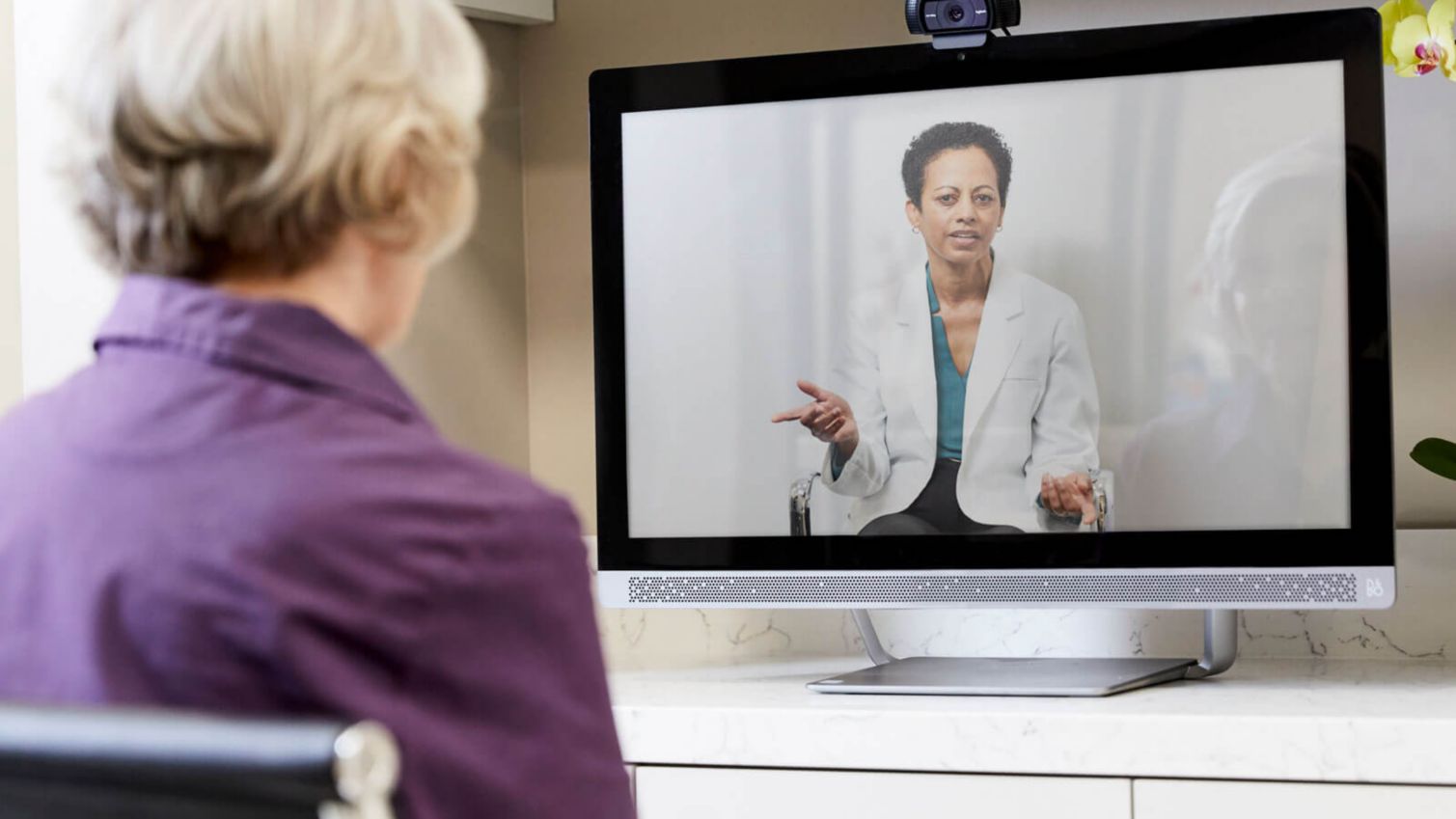 A woman has a videoconference appointment with a doctor using Humana’s telehealth service.