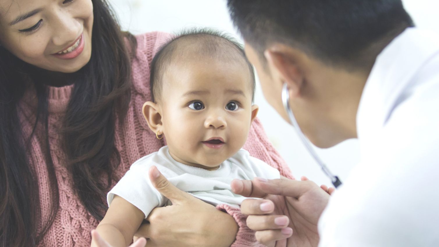 baby looking at medical professional