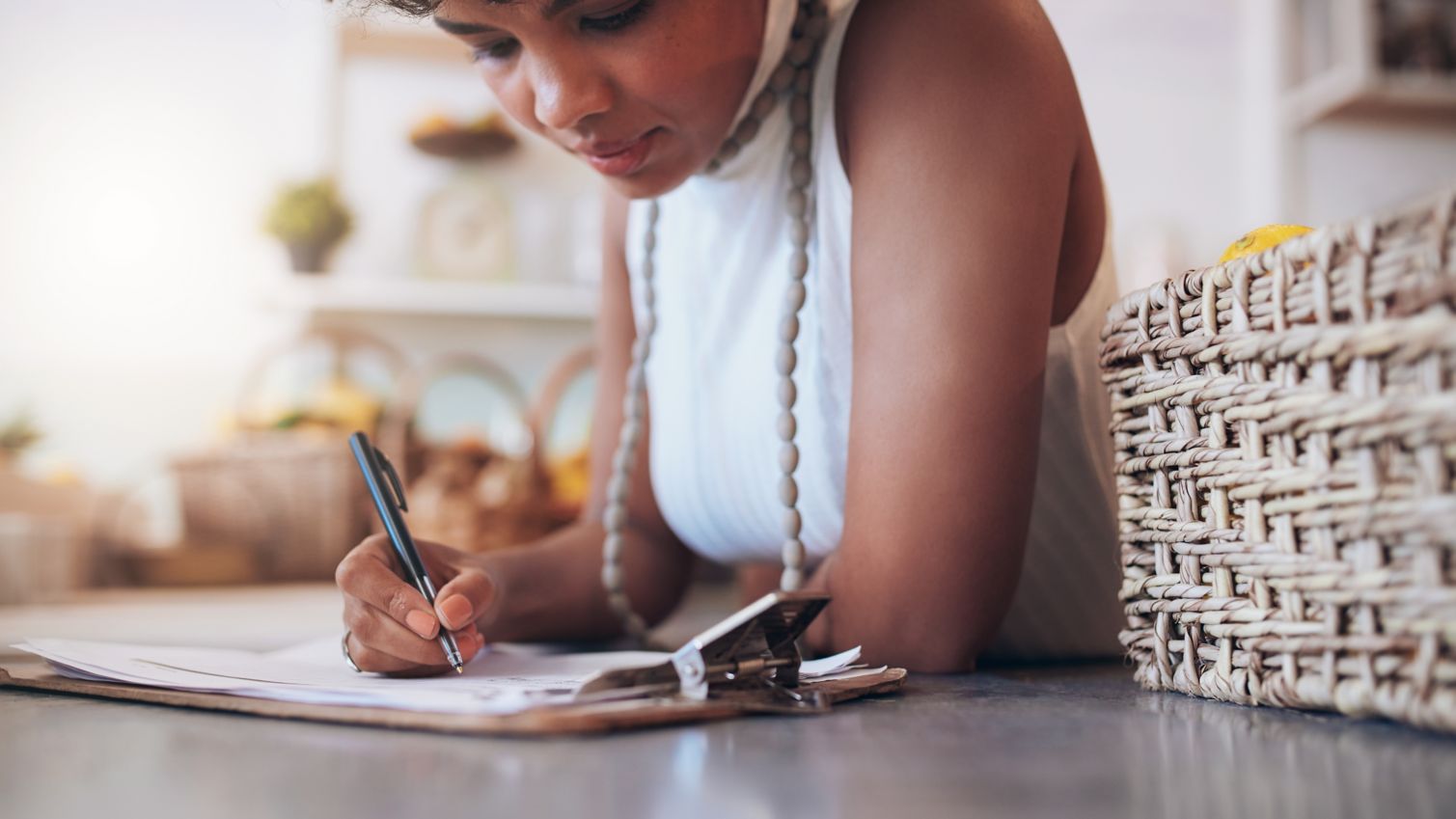 1 woman writing on a clipboard.