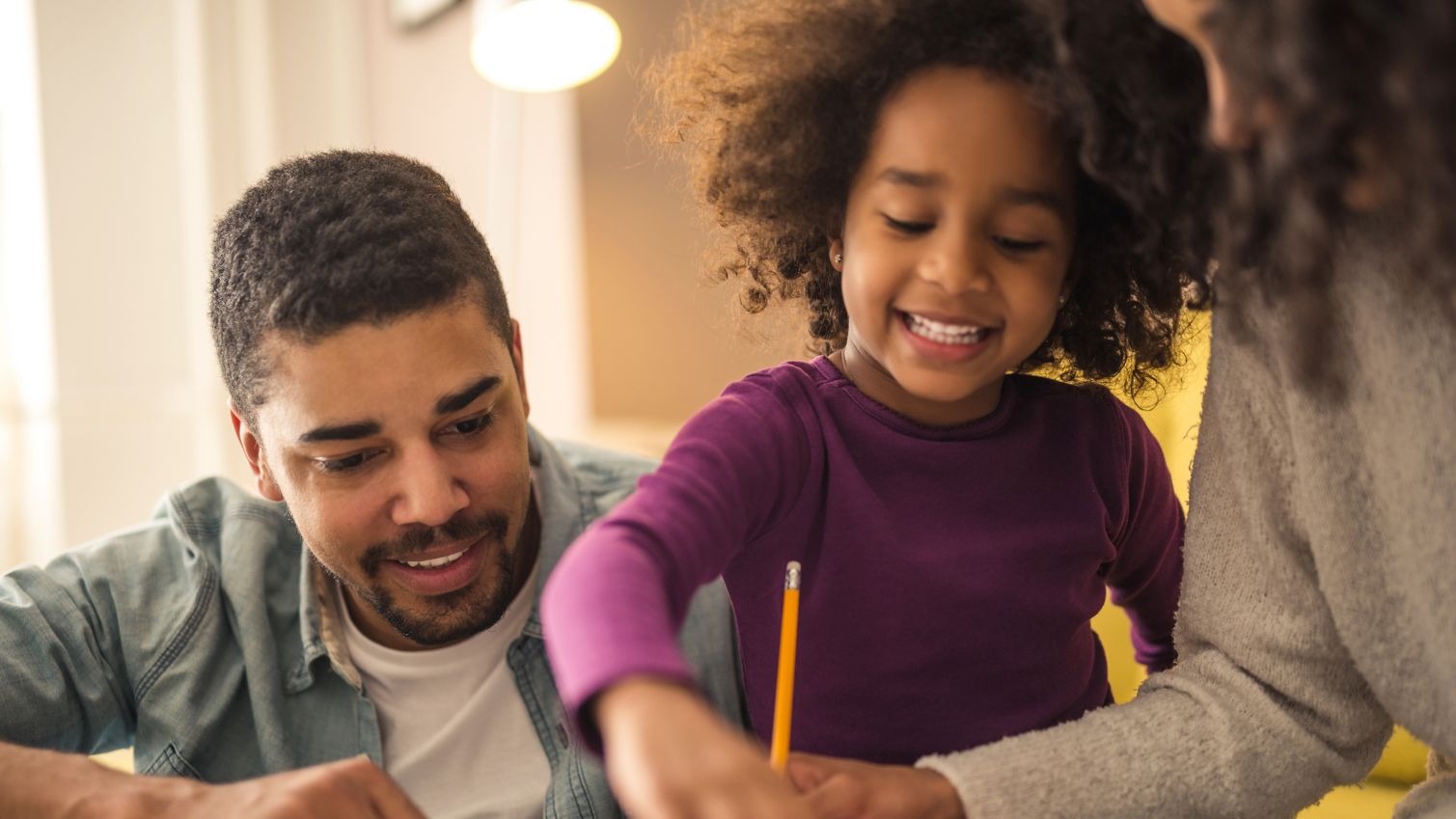 2 parents help their child with her homework.