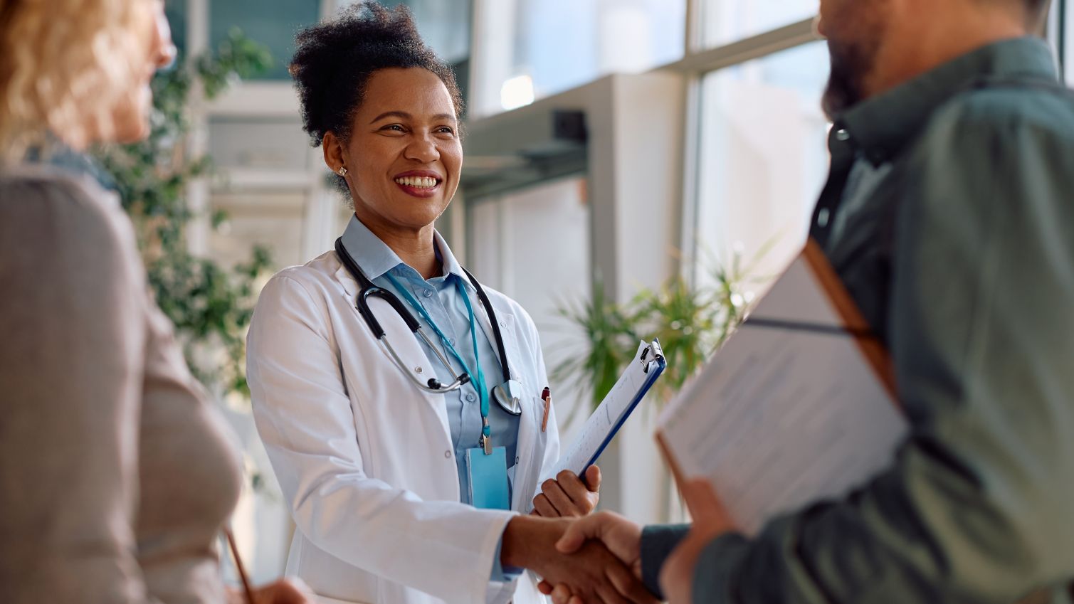 Happy doctor greeting patients at the clinic.
