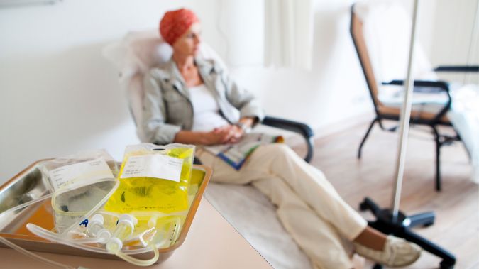 A tray of medicine sits on a table in front of a woman. 