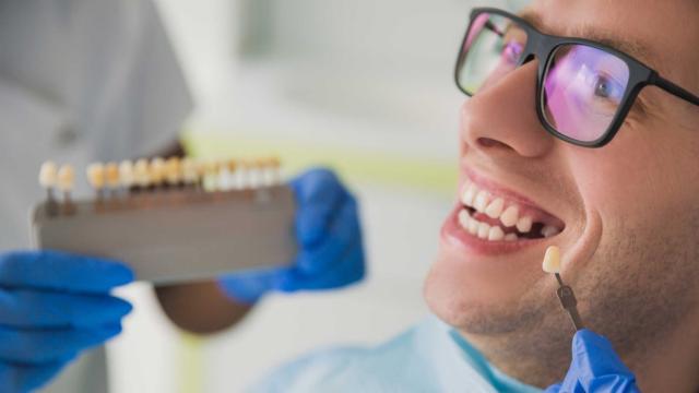A dental patient gets color matched for a veneer. 