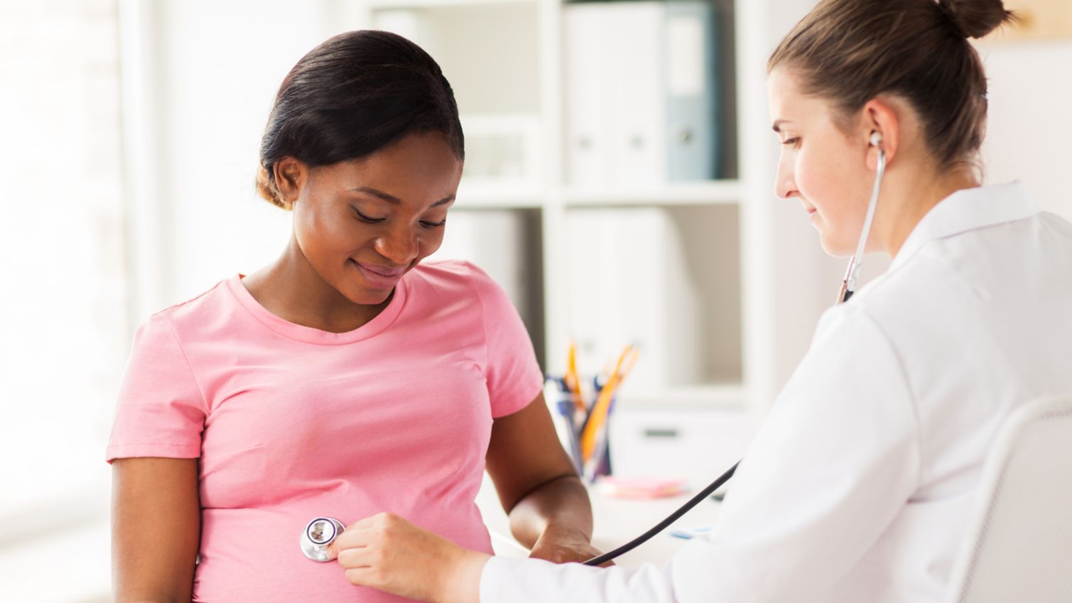 A female doctor examining a young pregnant woman