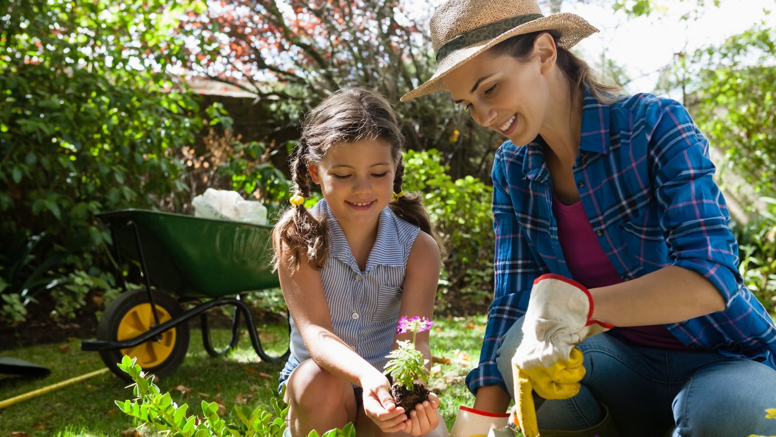 A mother and her daughter garden together.