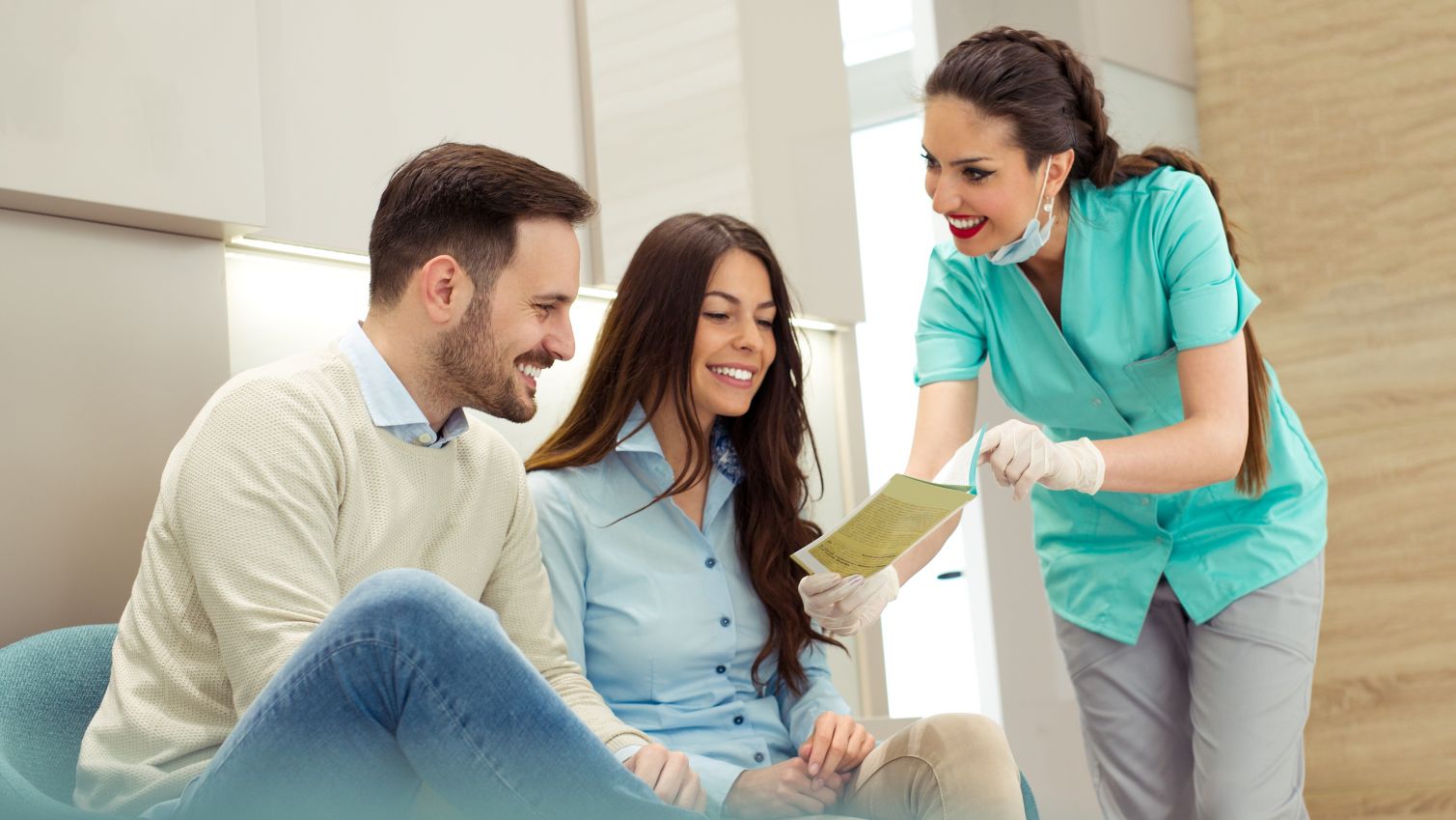 A dental assistant explains plan options to a couple