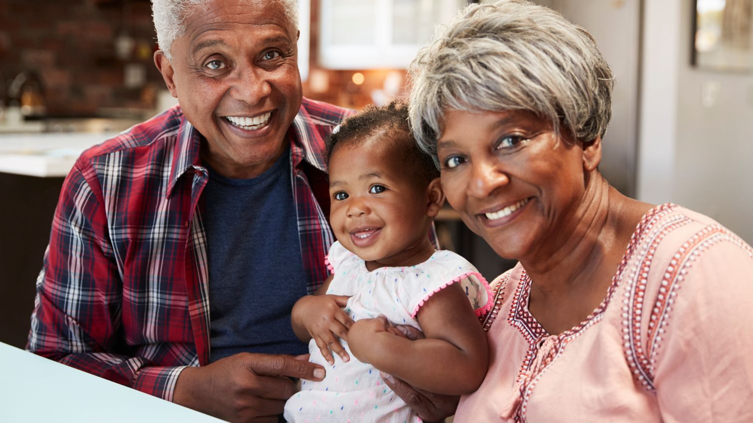 Grandparents holding granddaughter.