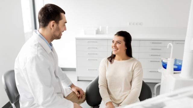 a dentist speaks to a patient in a dental office 