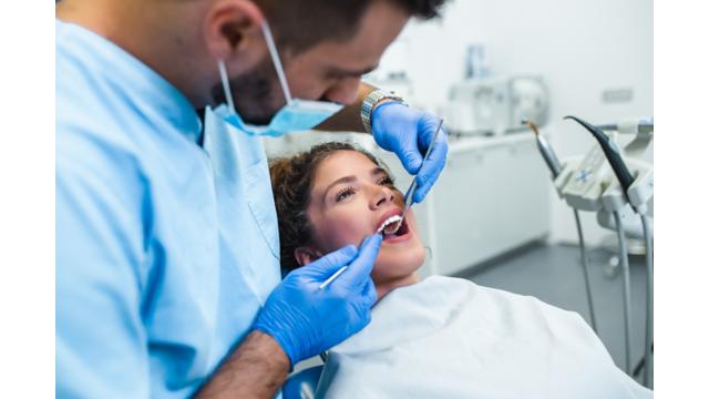 a dentist examines a patients teeth