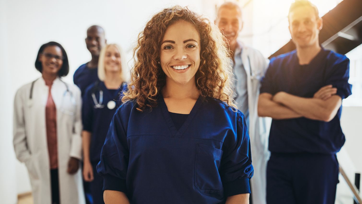 A provider smiles while standing in front of her colleagues. 