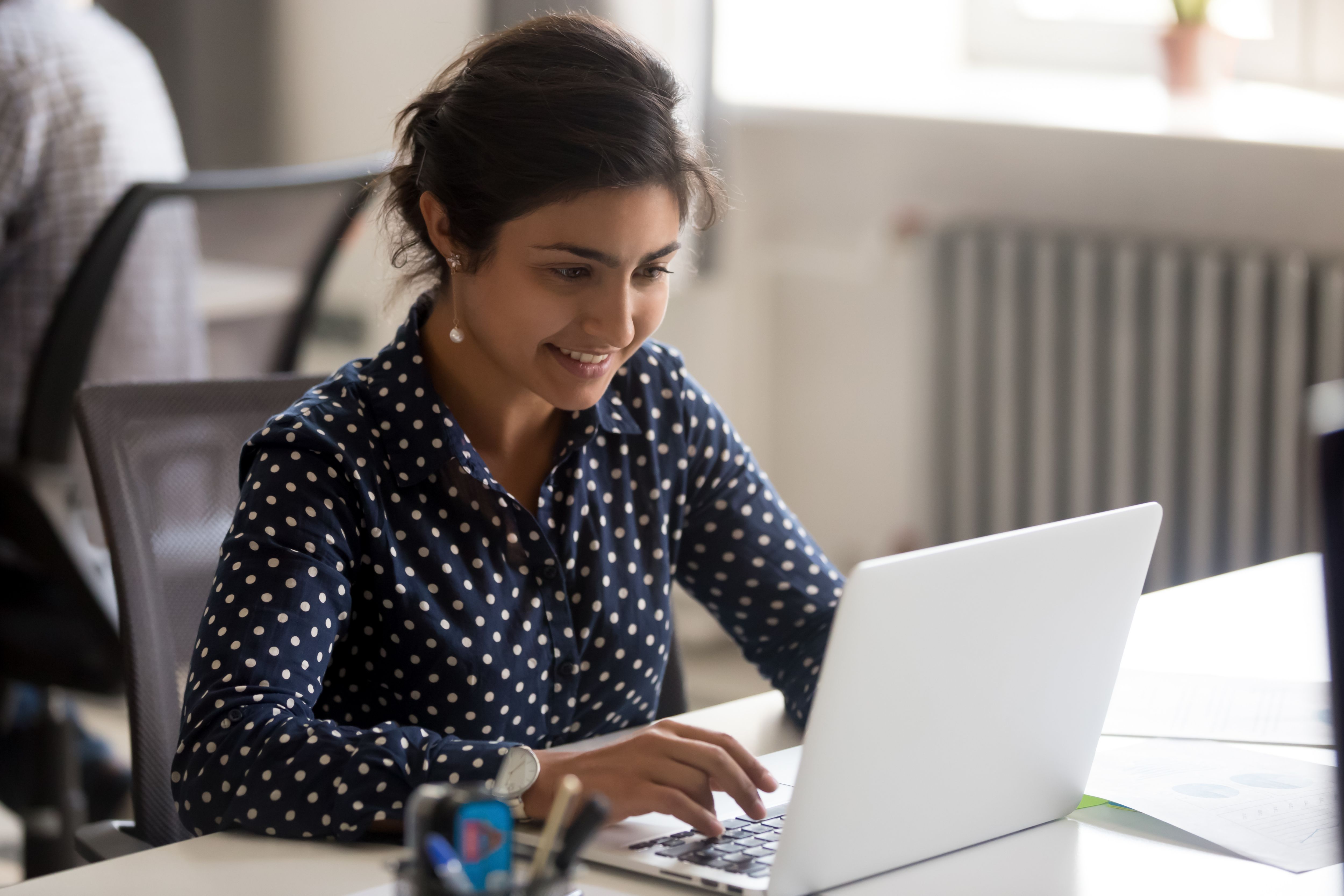 Smiling healthcare professional using laptop at workplace