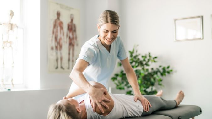 Modern rehabilitation physiotherapy worker with woman client.