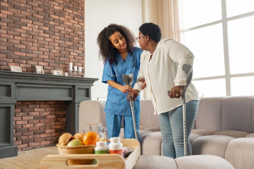 Woman at home getting helped by a nurse.