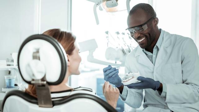 A dentist and a dental assistant prepare to check a patient’s teeth.