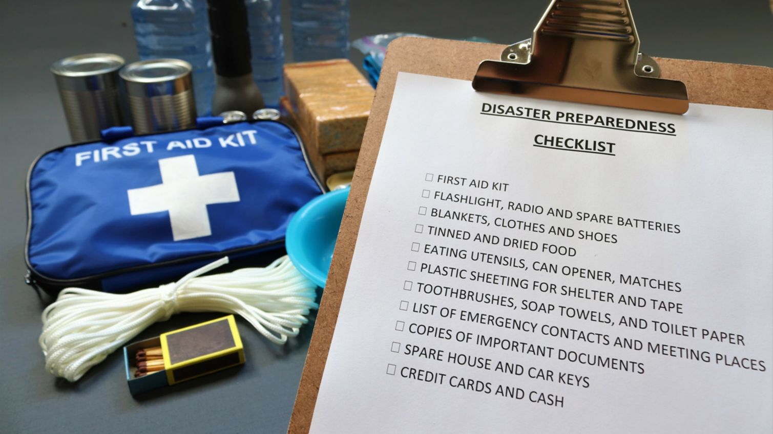 A disaster preparedness checklist and first aid kit sit on a table.