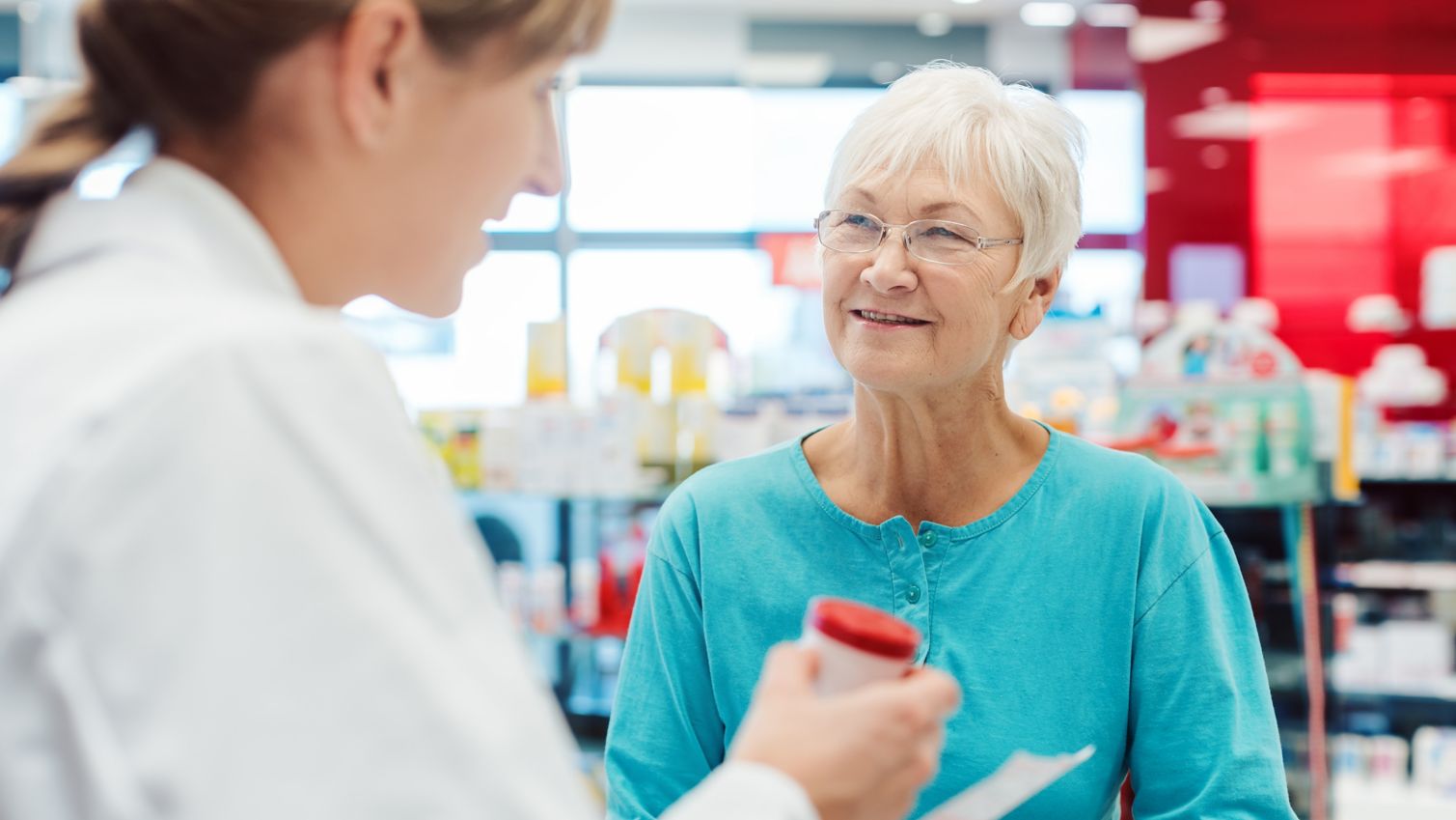 A retired woman talking to her pharmacist