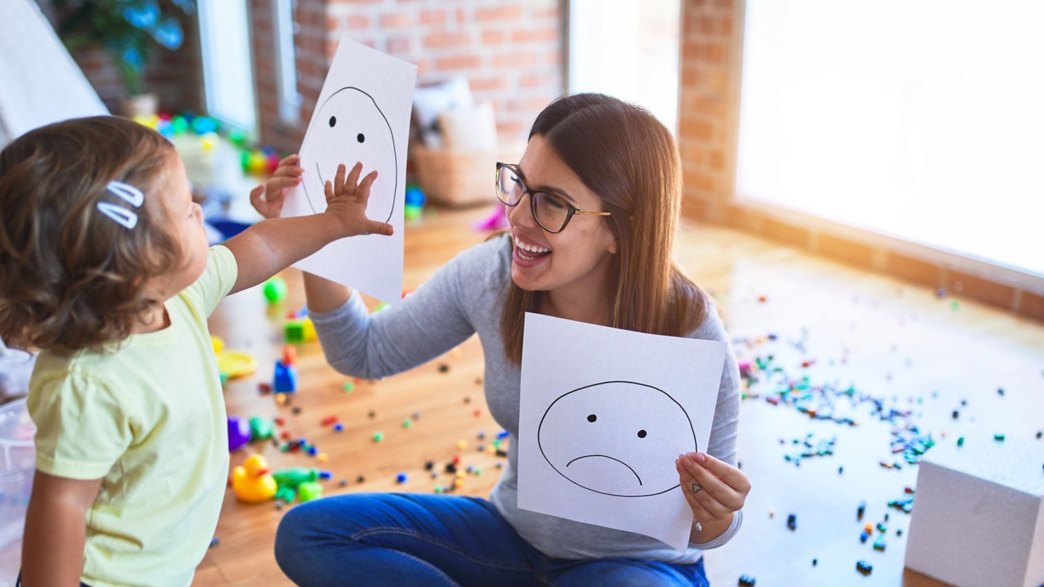 Child and adult playing games with face drawings