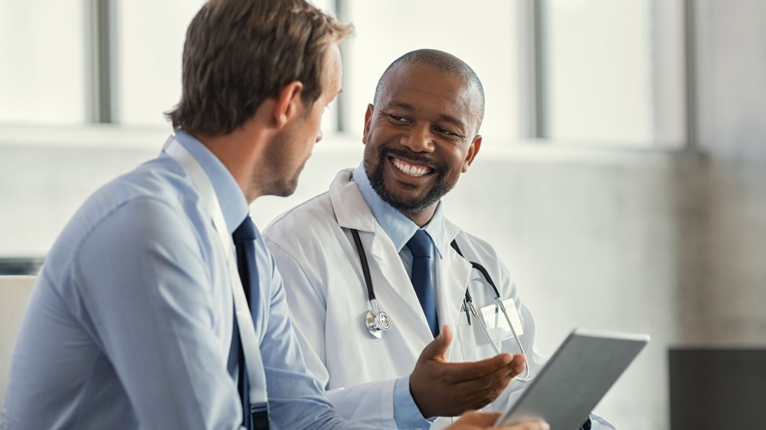 A male doctor going over a patient's information on a tablet