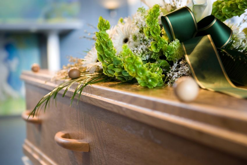 Flowers and ribbon adorn a casket.