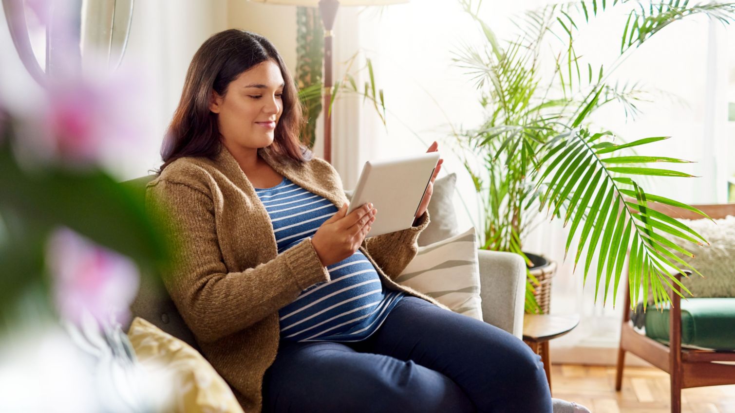 Member sitting on a couch looking at a tablet.