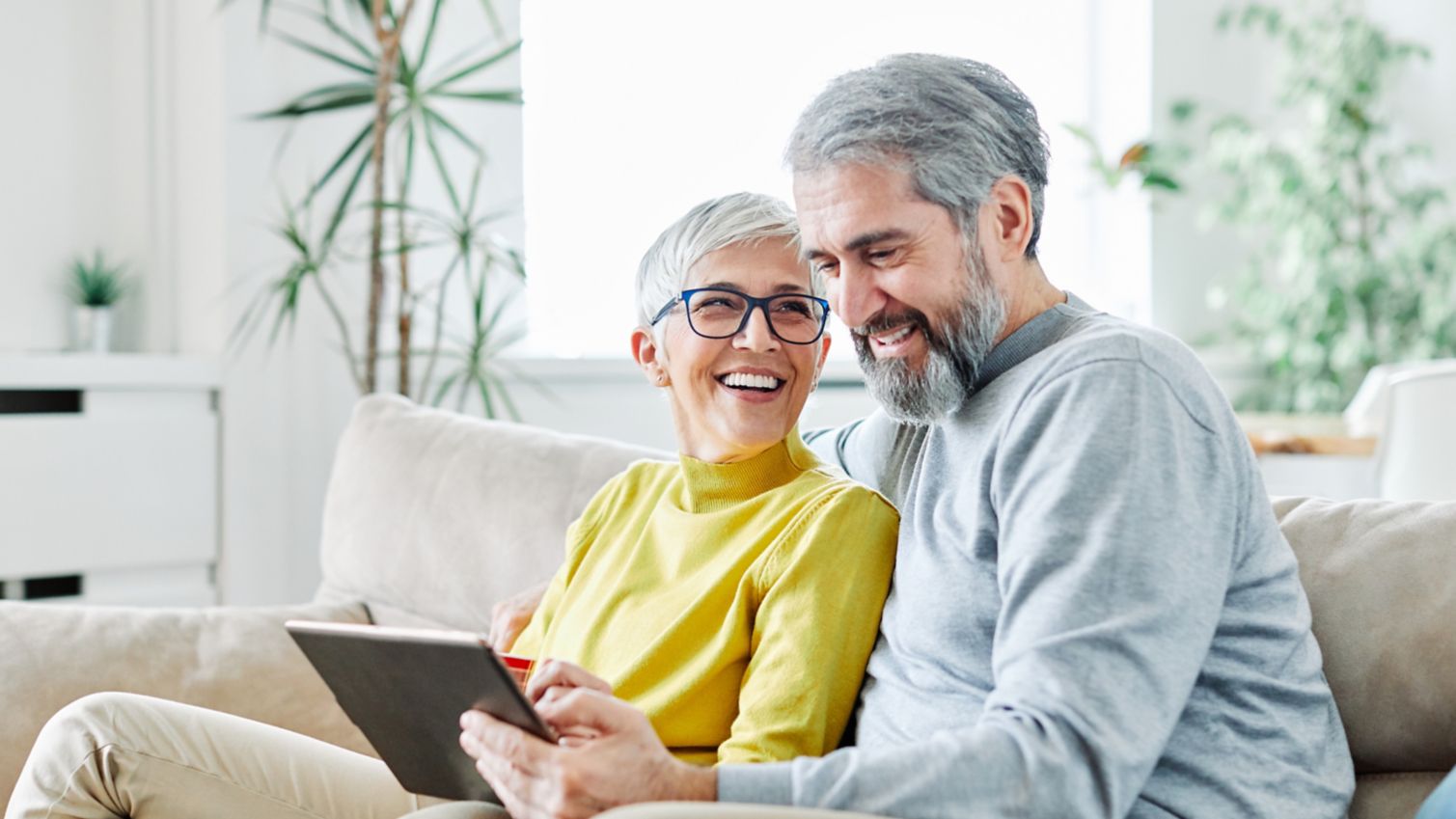 A retired couple sitting together smiling