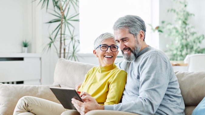 A retired couple sitting together smiling