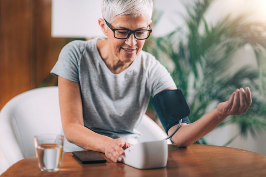 Woman using a blood pressure monitor. 