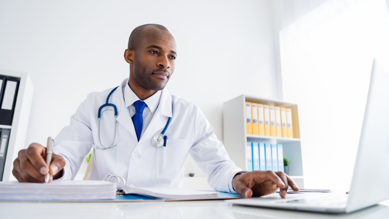 Healthcare professional researching on laptop