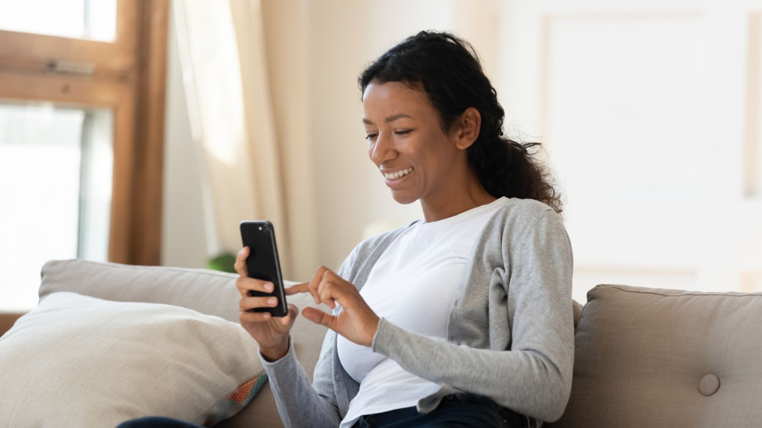 woman sit on couch, looking at the cellphones
