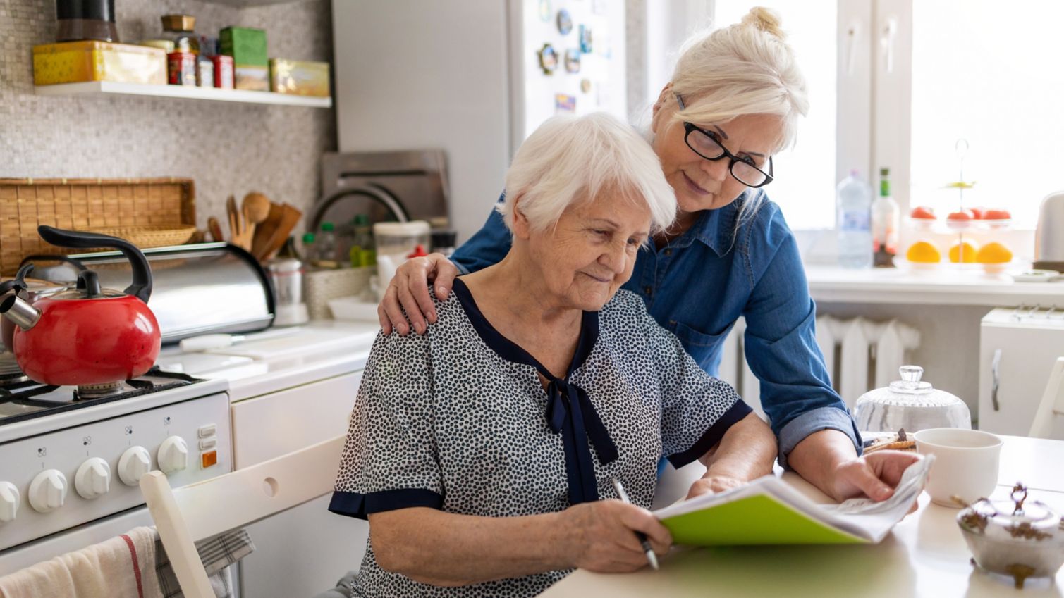 people looking at a notebook in the kitchen