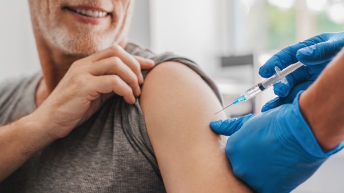 Man getting a vaccine shot in his shoulder.