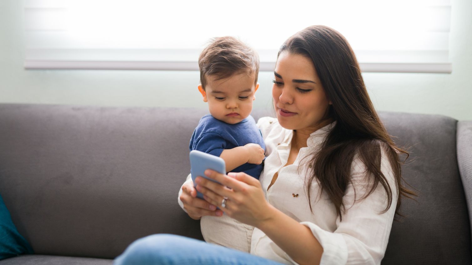 Mother and son using smart phone at home
