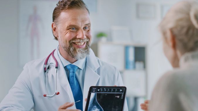 A doctor reviews a scan result with a patient. 