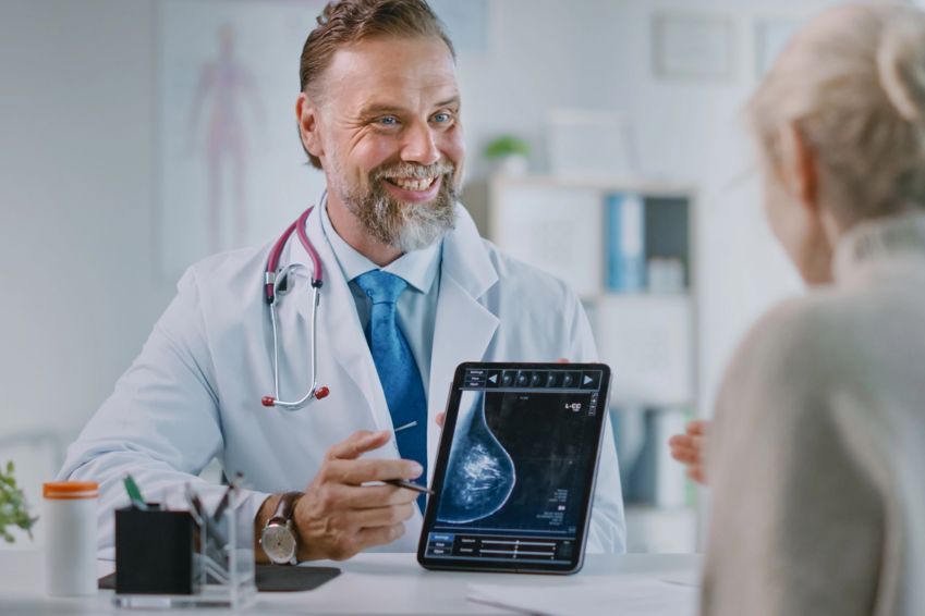 A doctor reviews a scan result with a patient. 