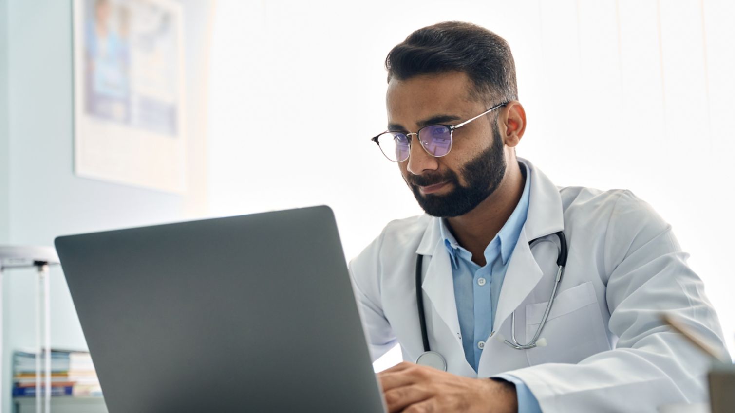 A male provider working on a computer.