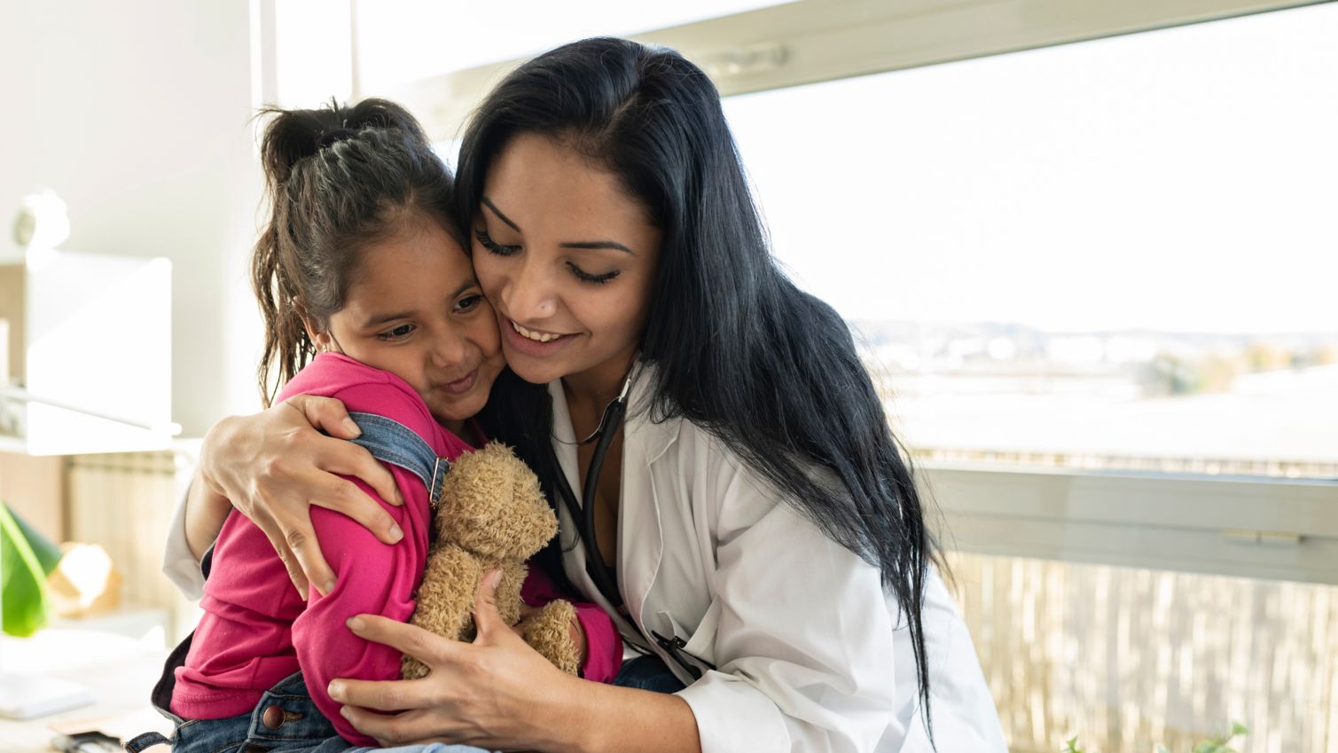 healthcare professional hugging child