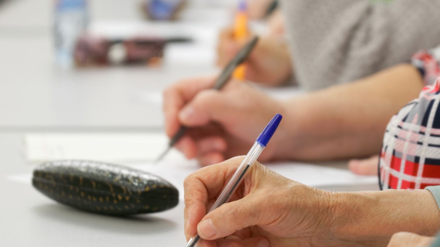 two people writing on paper