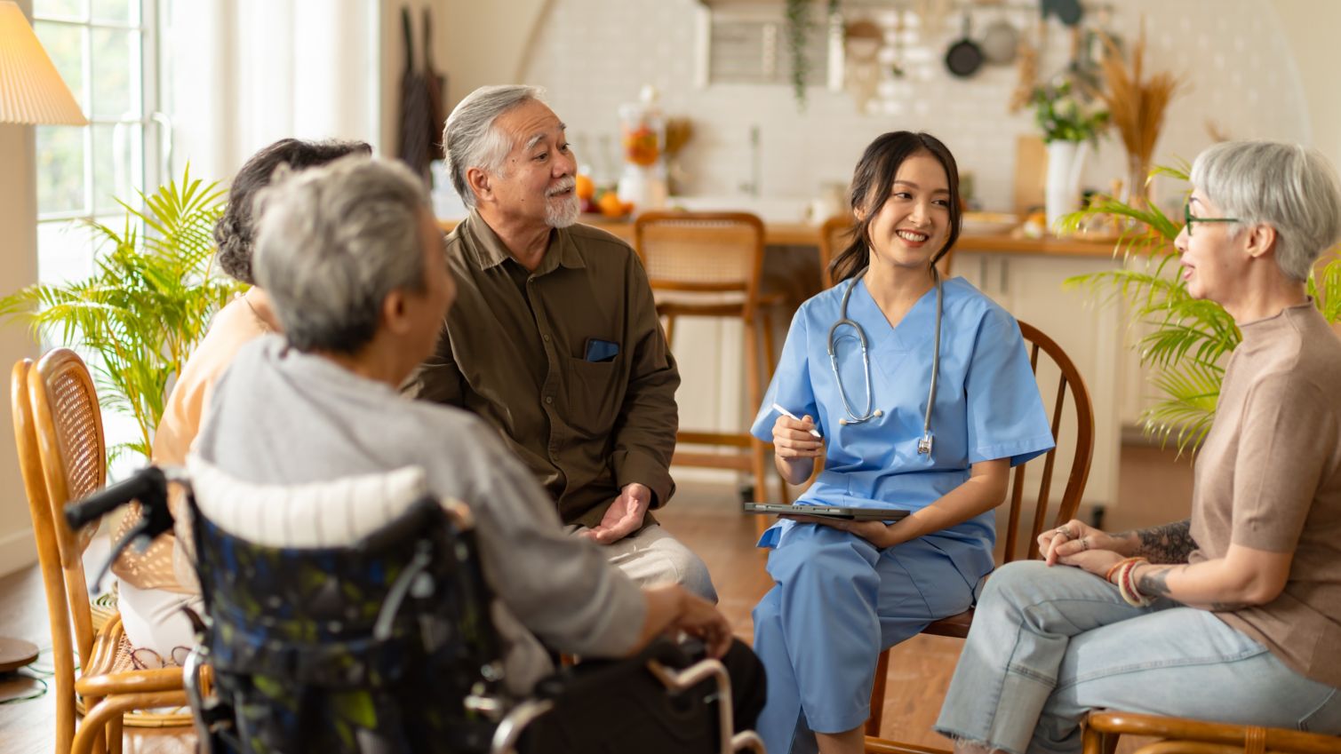 A healthcare professional talks to a group of retired seniors in a circle