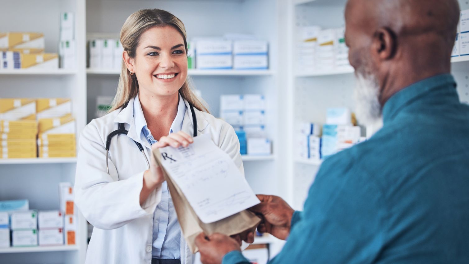 Pharmacist handing prescription to member